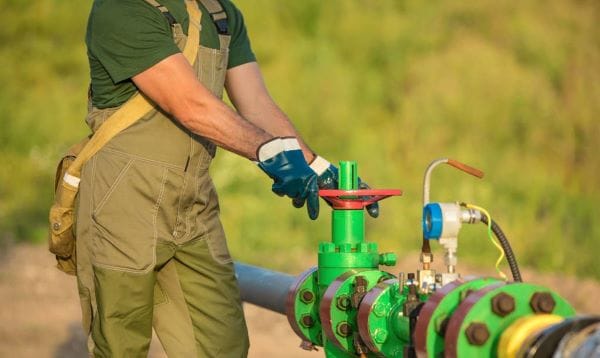 A worker operates a valve